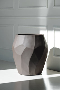 Gefacetteerde plantenbak Liscio Ash Brown in zonlicht